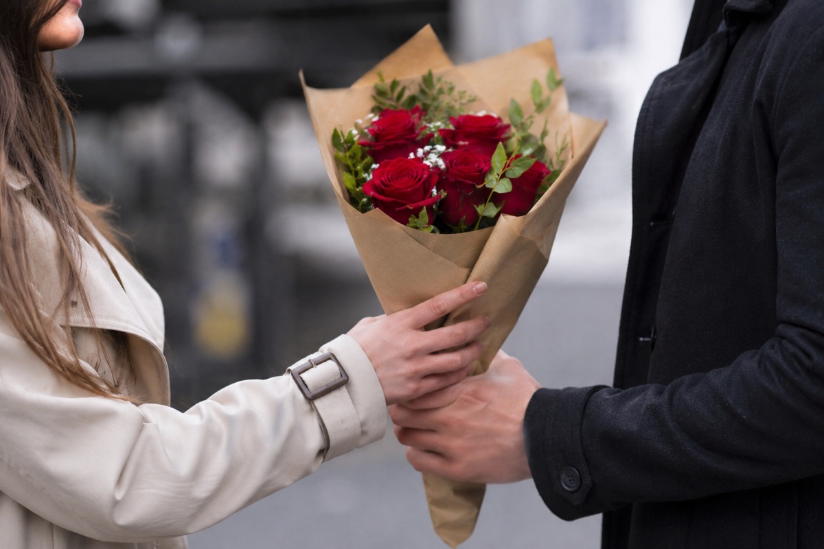 A couple exchanging a bouquet of red roses
